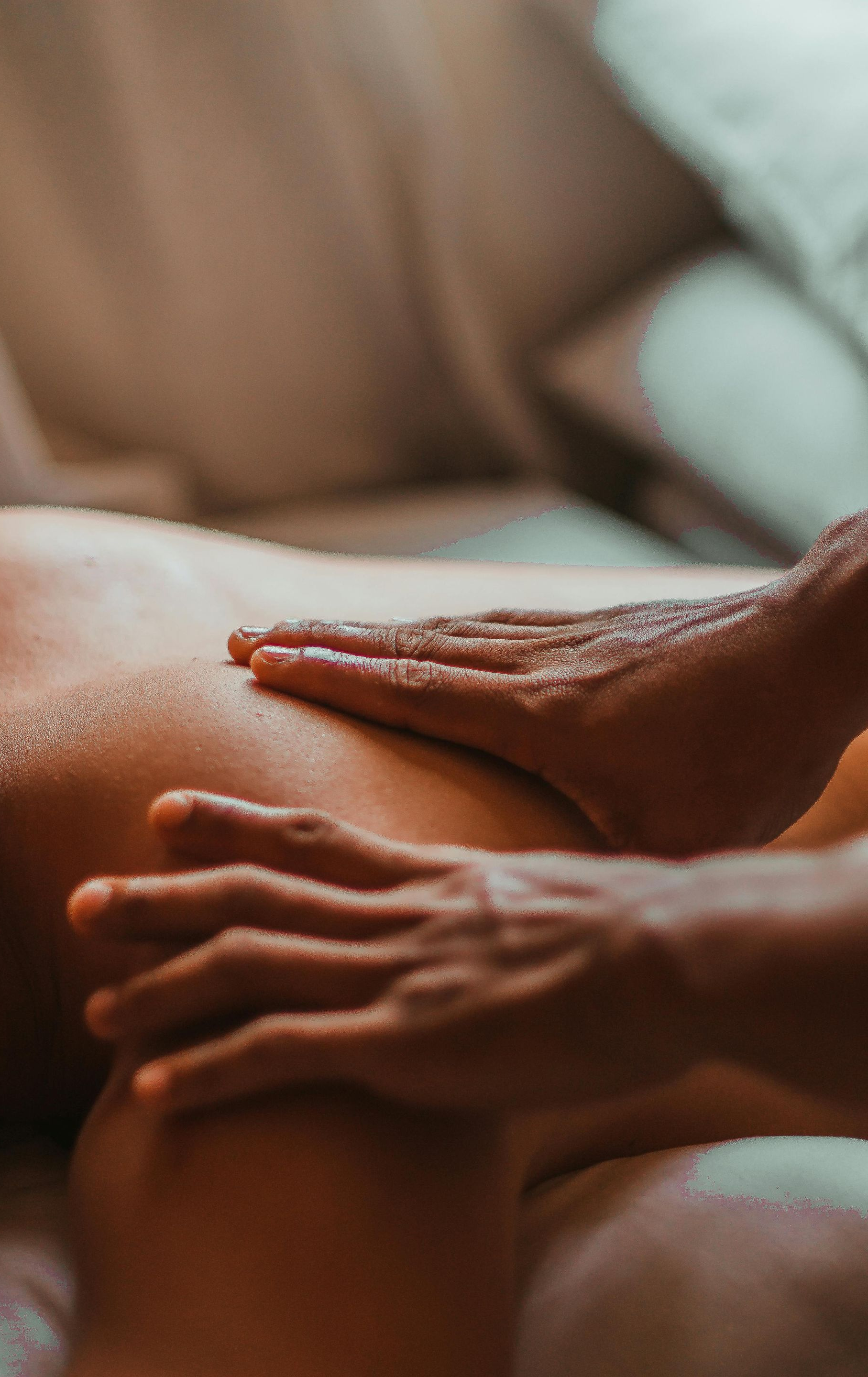 Hands giving back massage, applying pressure to bare back.