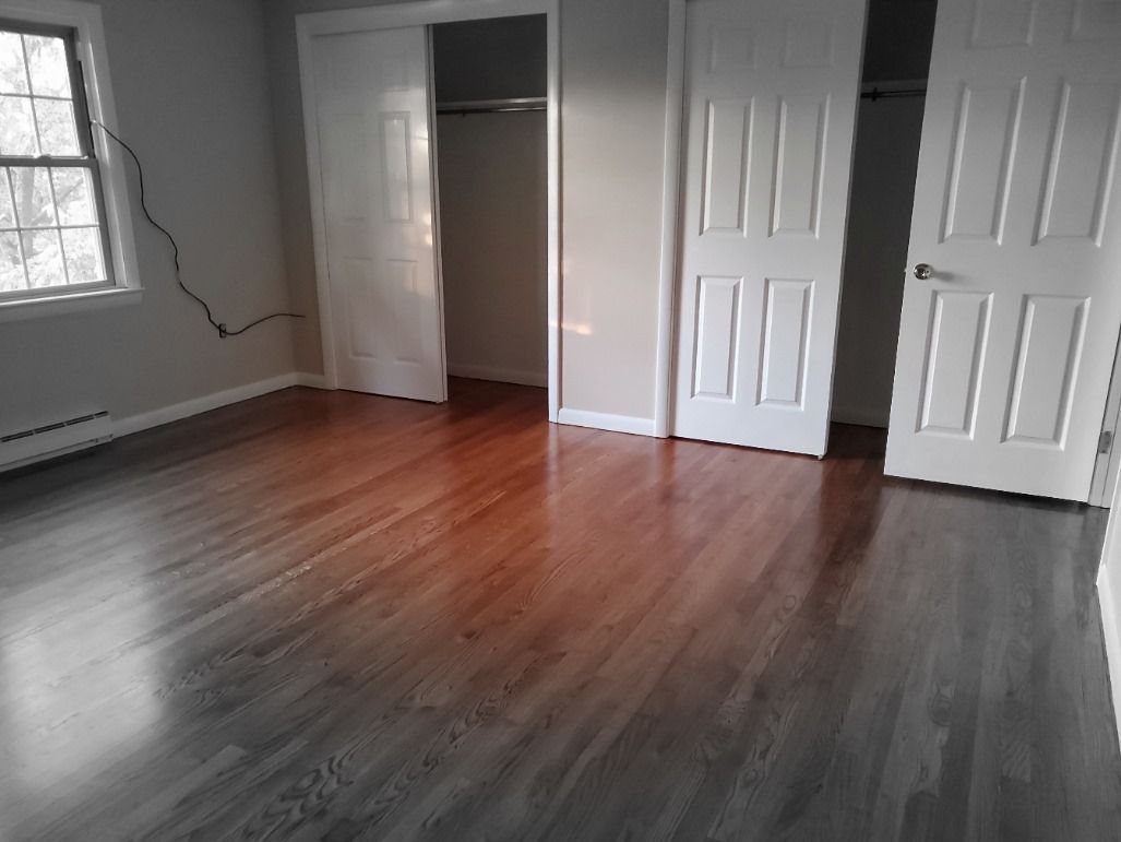 An empty room with hardwood floors and white doors