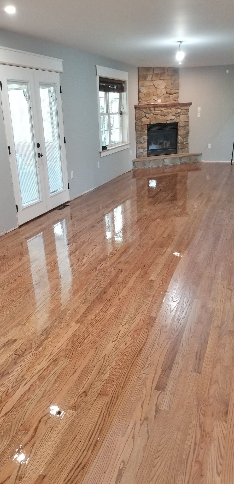 A living room with hardwood floors and a fireplace.