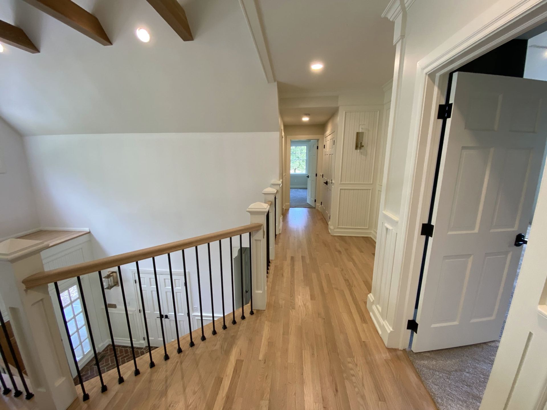 A hallway with hardwood floors and stairs leading up to the second floor