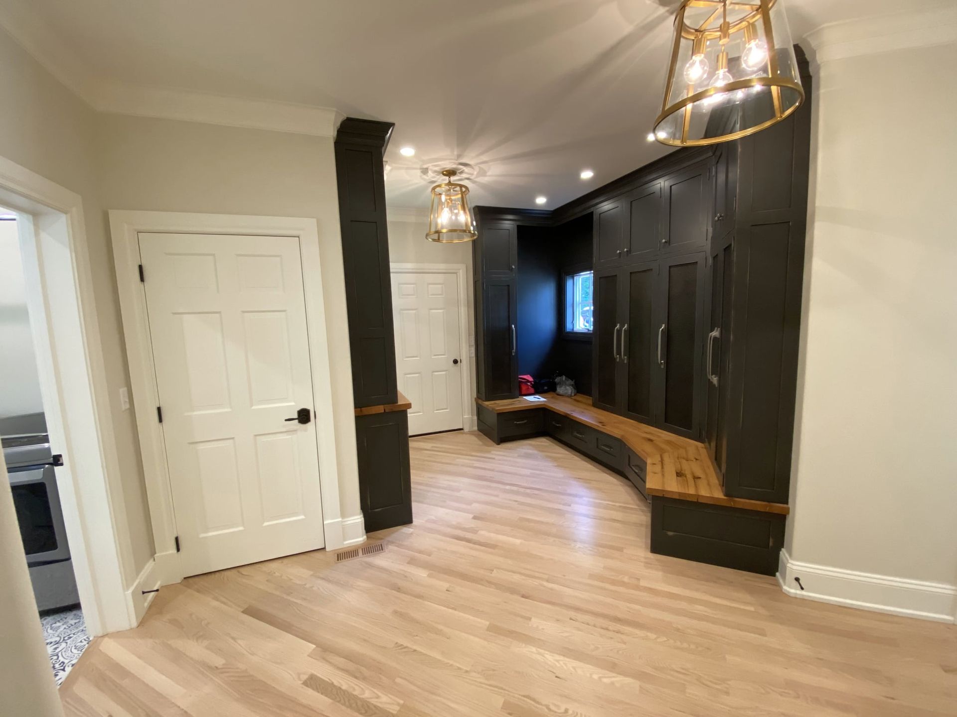A hallway with hardwood floors and black cabinets