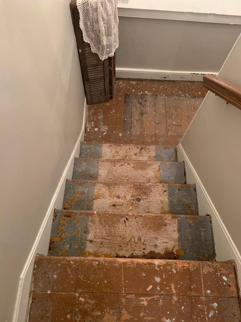A staircase with a wooden floor and a wooden railing.
