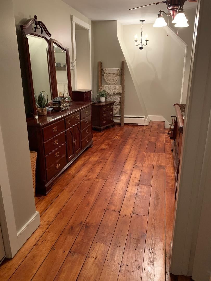 A hallway with hardwood floors and a dresser