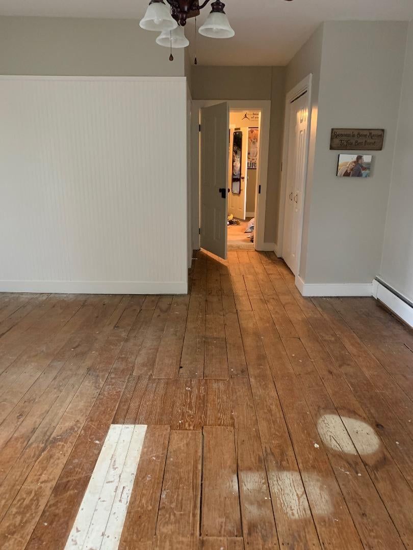 An empty room with wooden floors and a sign that says 