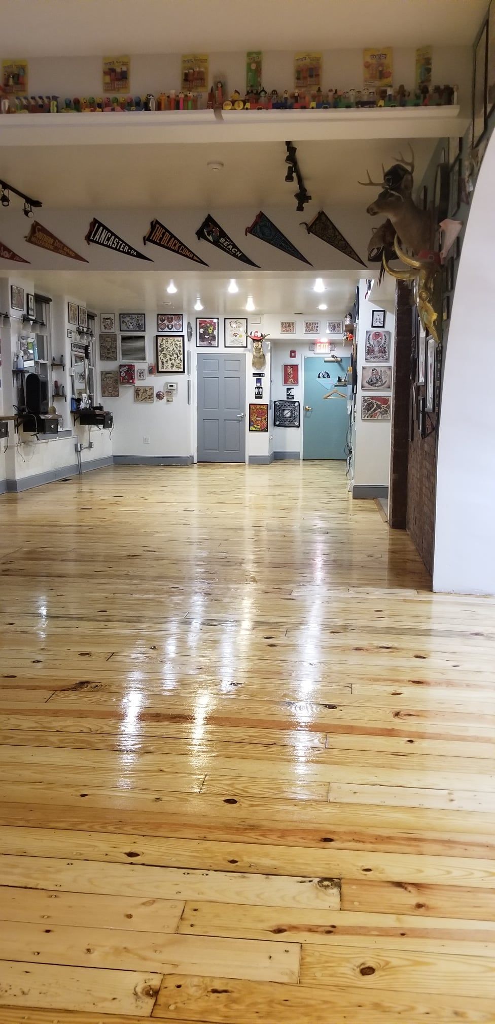 A large room with a wooden floor and flags on the ceiling