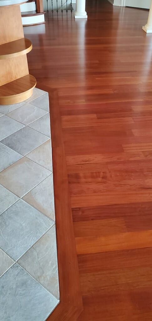 A wooden floor with a staircase in the background