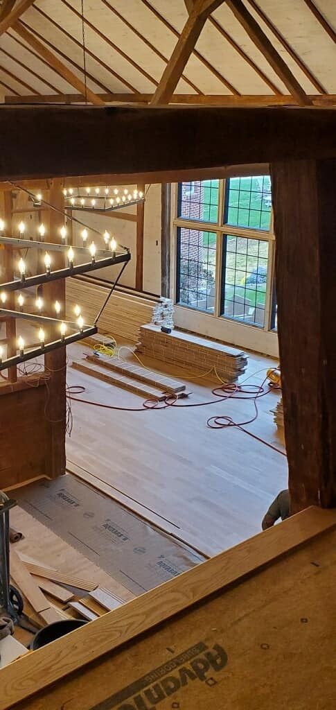 A room with a wooden floor and a chandelier hanging from the ceiling.