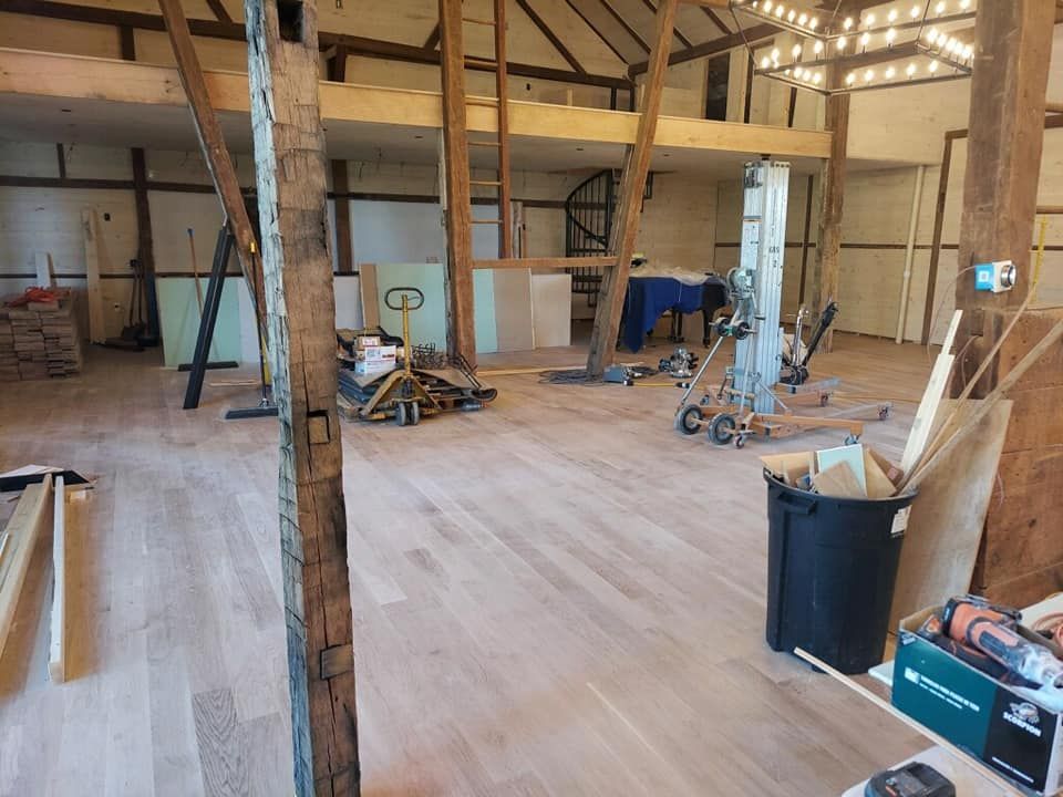 A large room with wooden floors and a black trash can