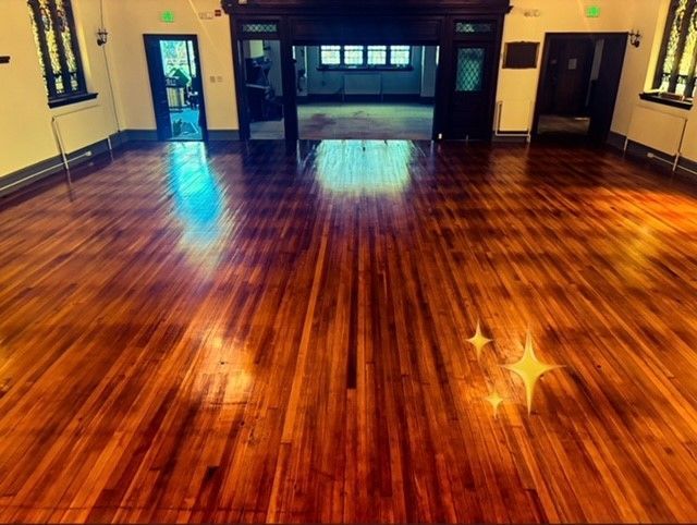 A large room with a wooden floor and a fireplace