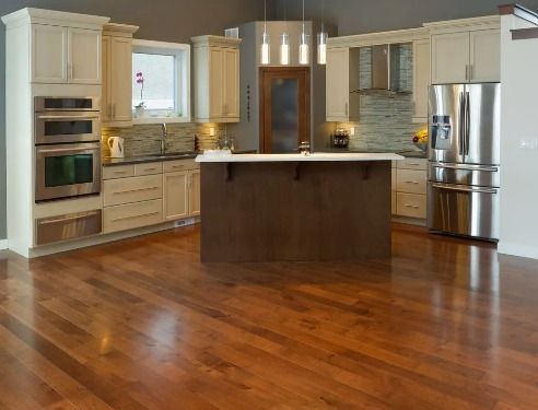 A kitchen with wooden floors and stainless steel appliances