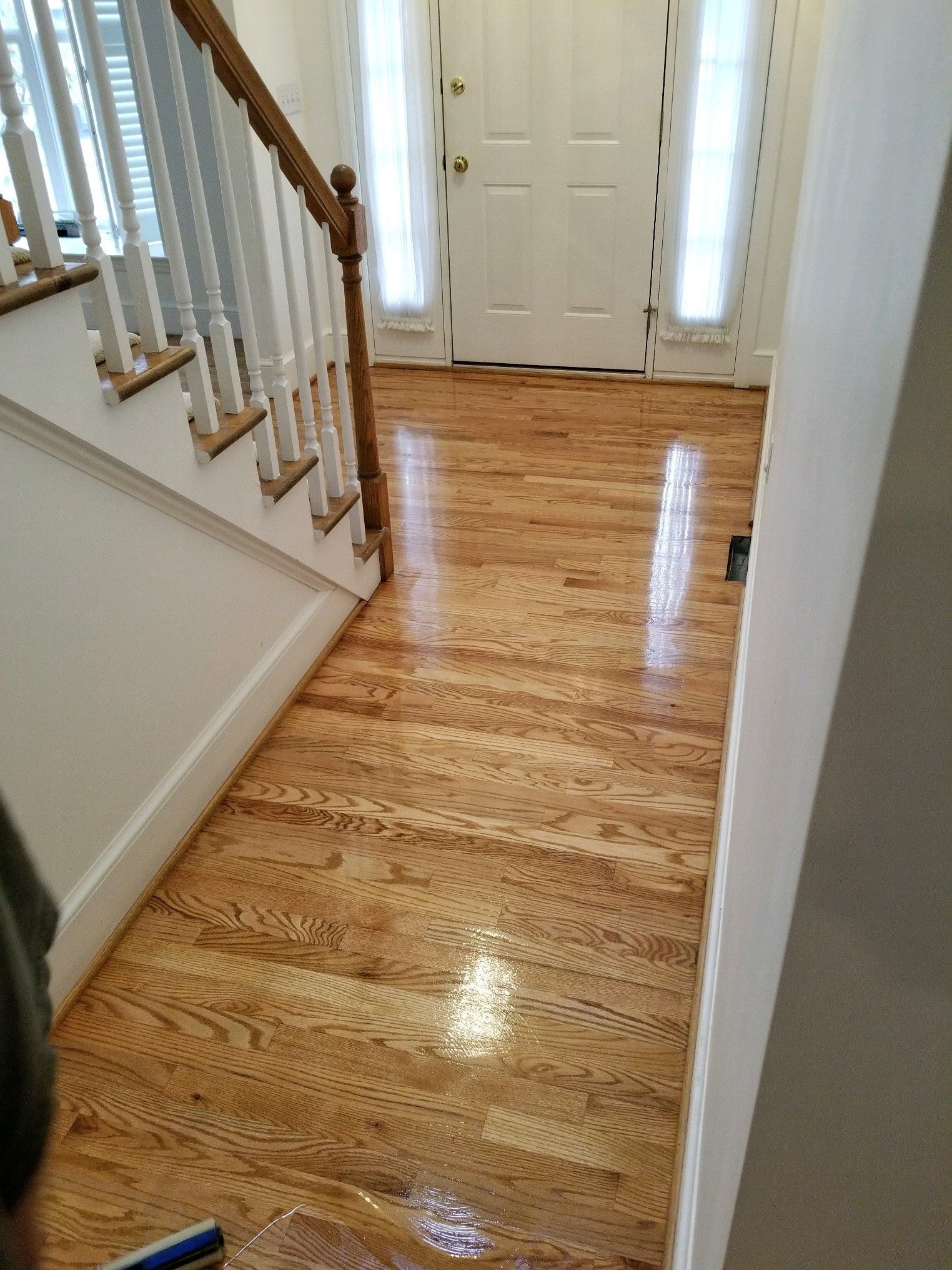 A hallway with hardwood floors and stairs in a house