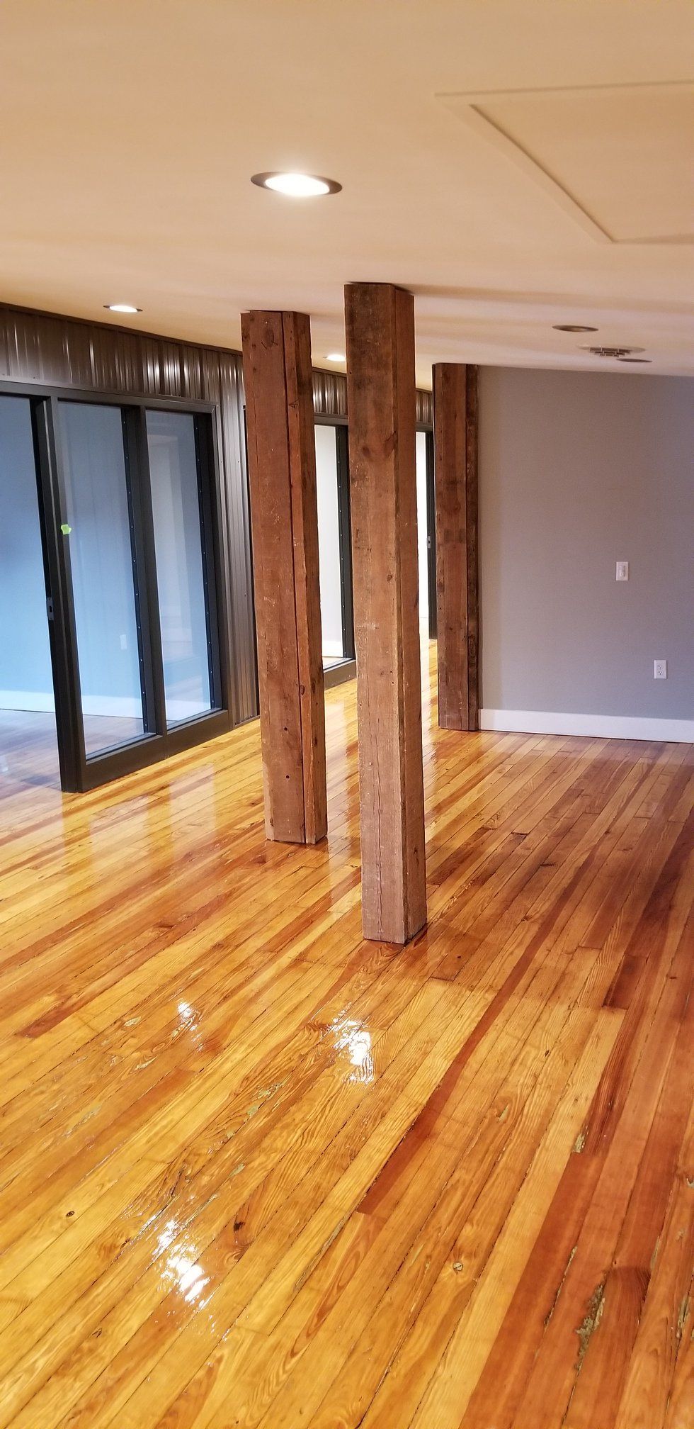 An empty room with wooden floors and pillars