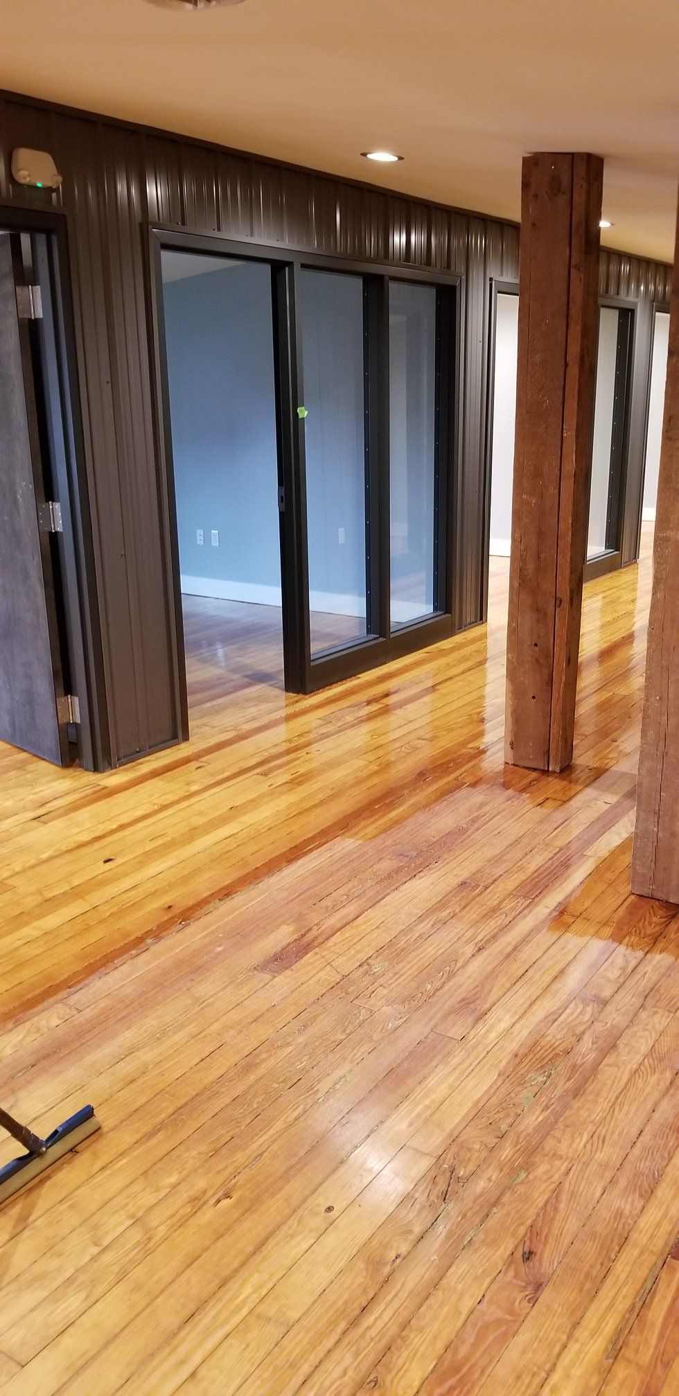 A room with a wooden floor and a large mirror on the wall.