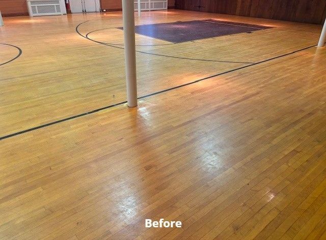 A before photo of a wooden floor in a gym