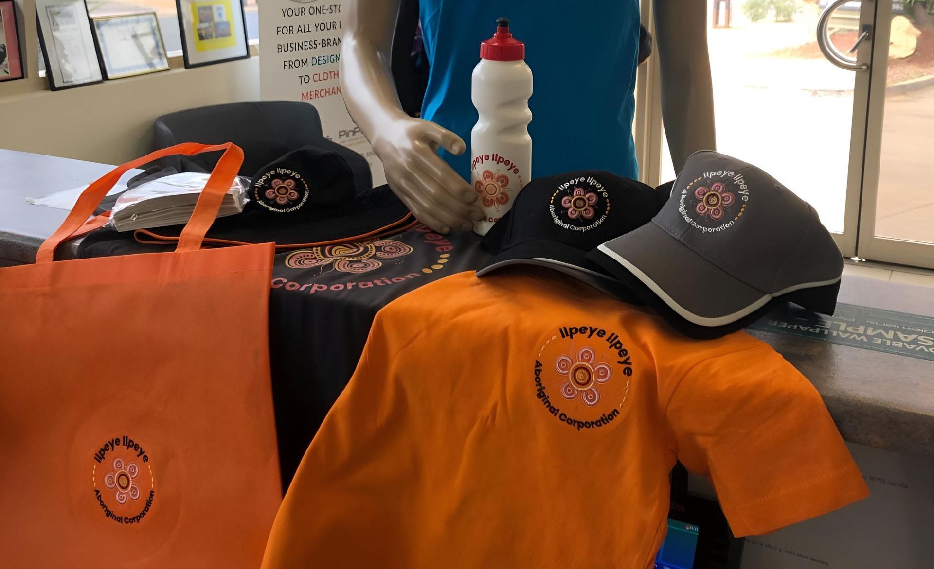 a Table With a Bunch of Shirts and Hats on It — Pinpoint In Tennant Creek, NT