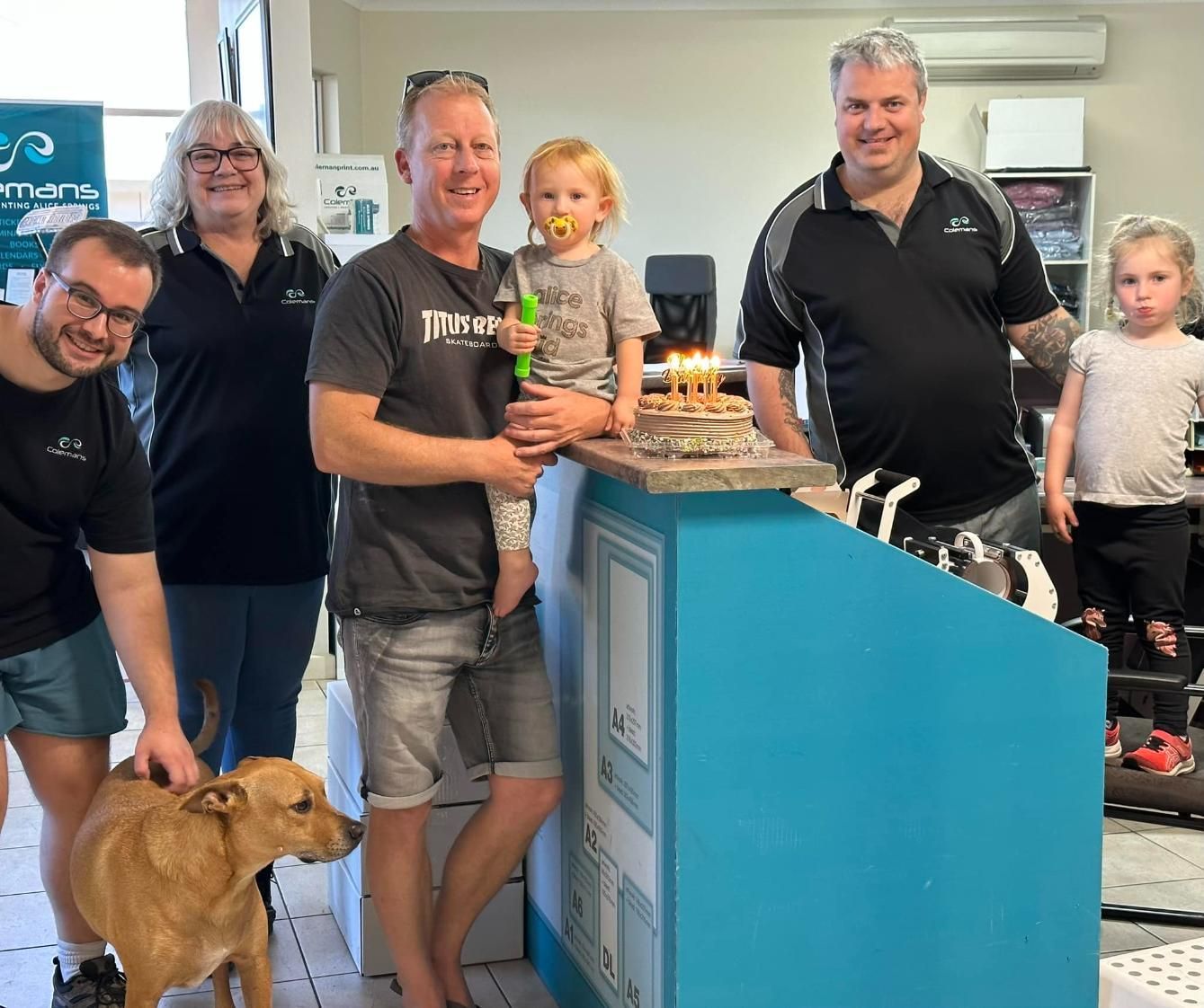a Group of People Standing Around a Counter With a Dog — Pinpoint In Tennant Creek, NT
