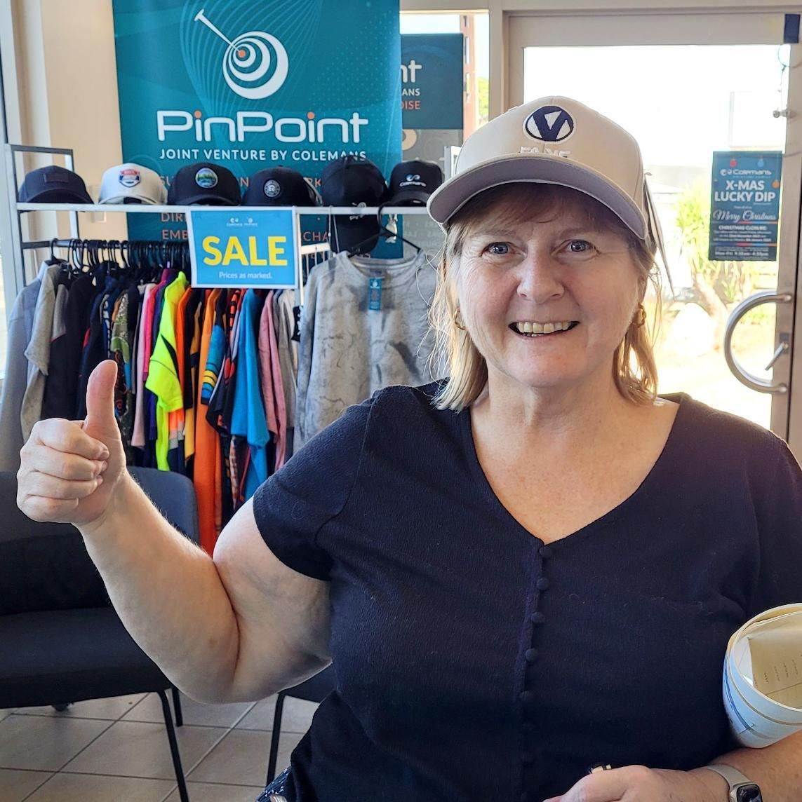 a Woman is Giving a Thumbs Up in Front of a Pinpoint Sign — Pinpoint In Alice Springs, NT