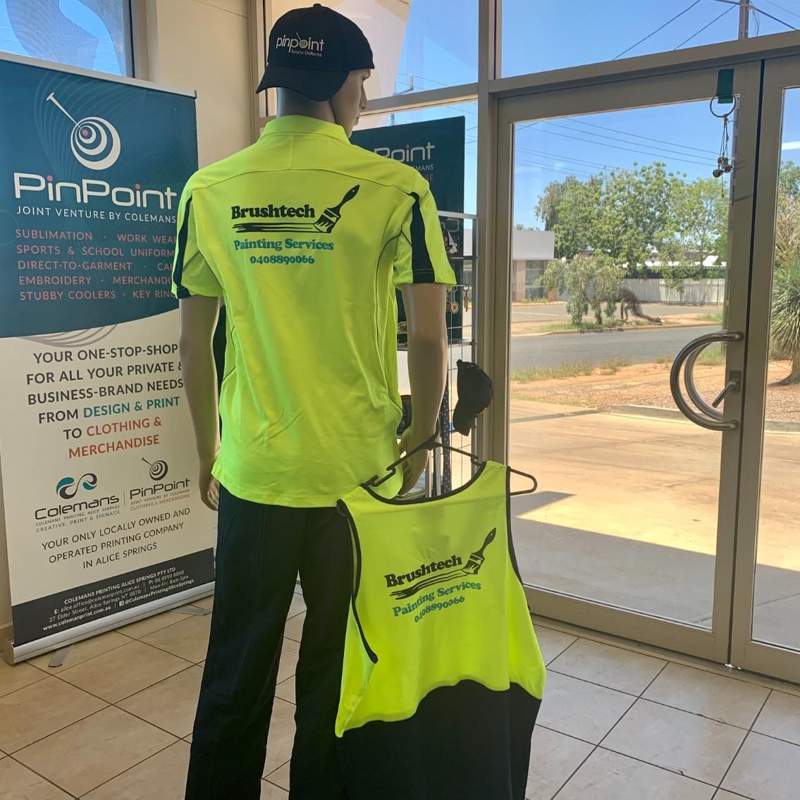 a Man in a Neon Yellow Shirt is Standing in Front of a Pinpoint Sign — Pinpoint In Alice Springs, NT