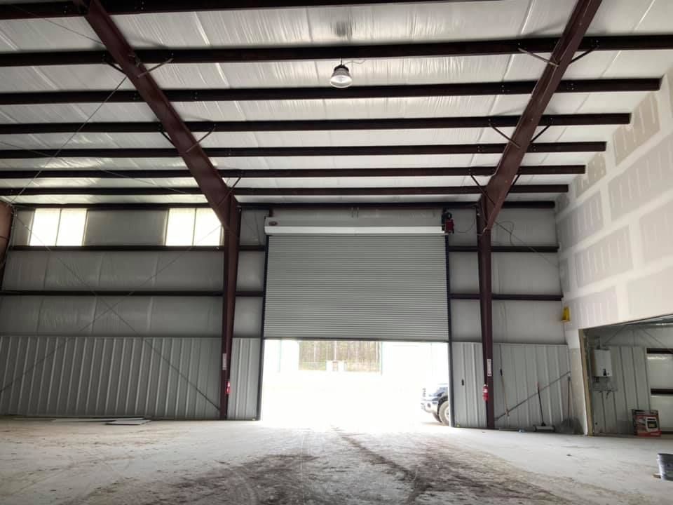 An empty warehouse with a large garage door open