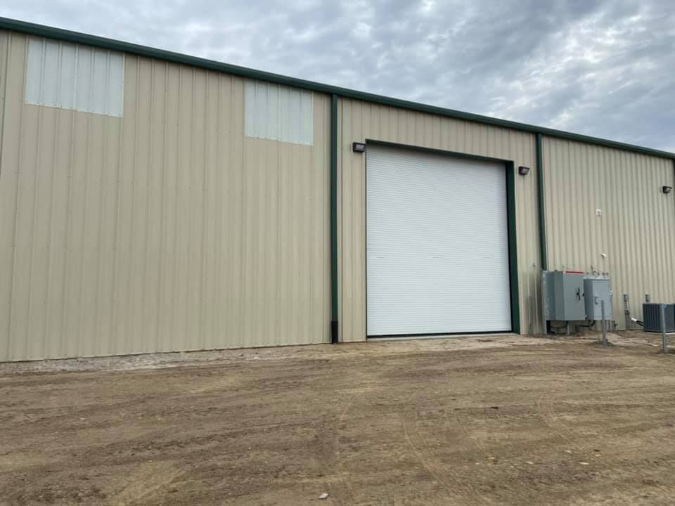 A large metal building with a large white garage door.