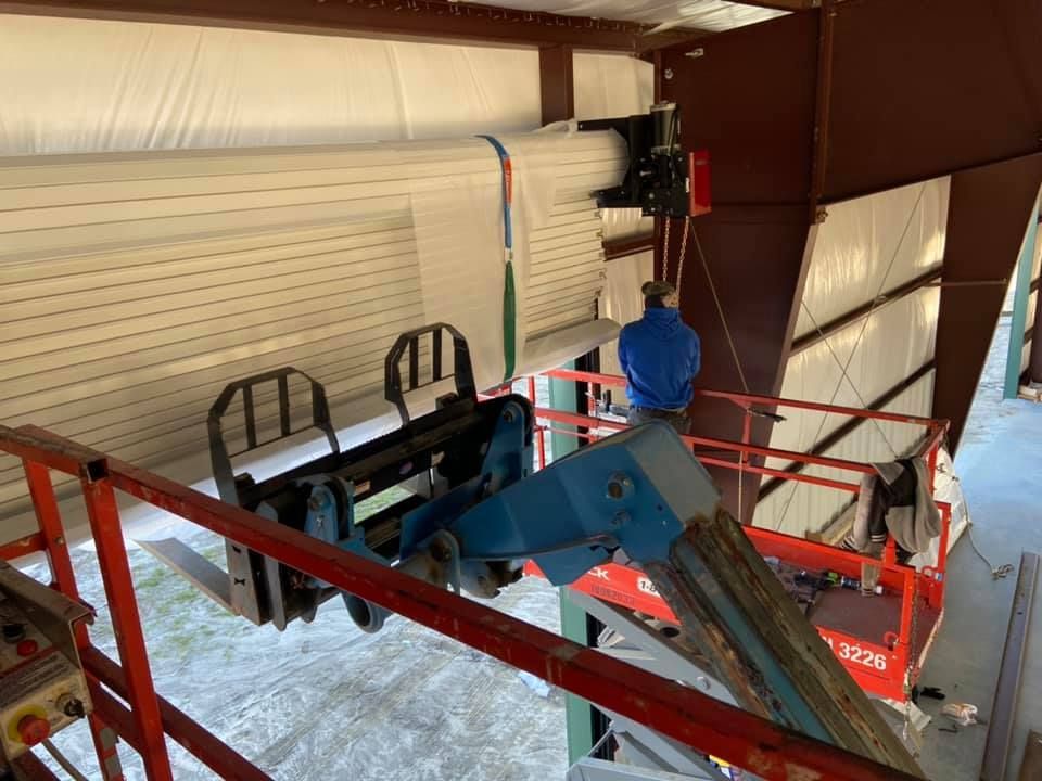A man is working on a forklift in a building.