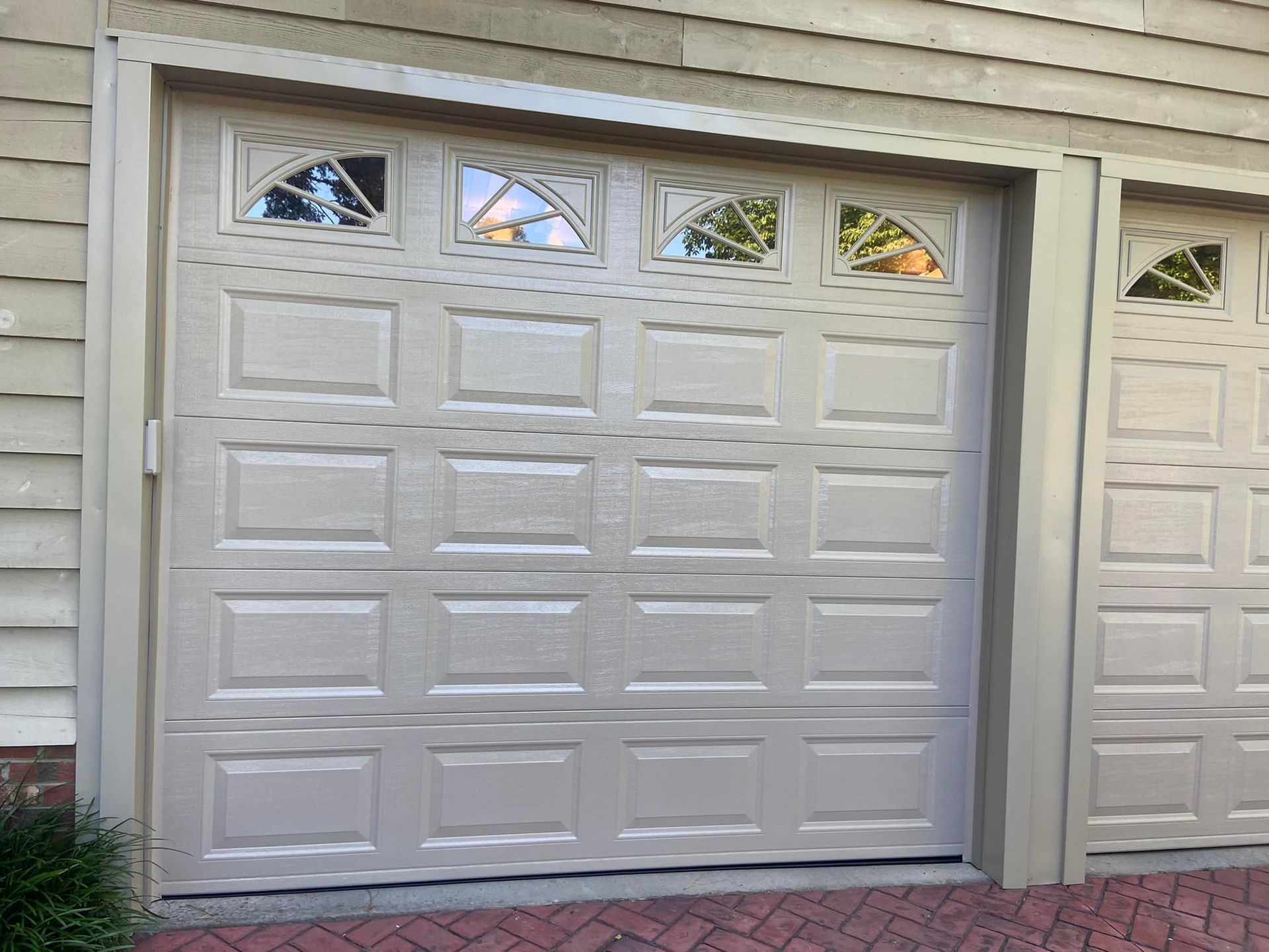 A white garage door with a lot of windows on it