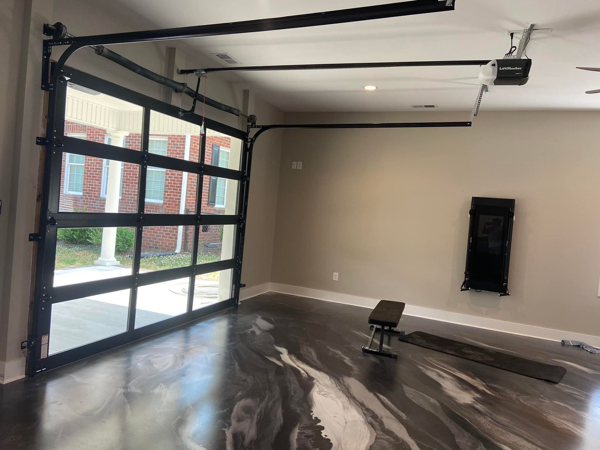 A garage with a large garage door and a bench.