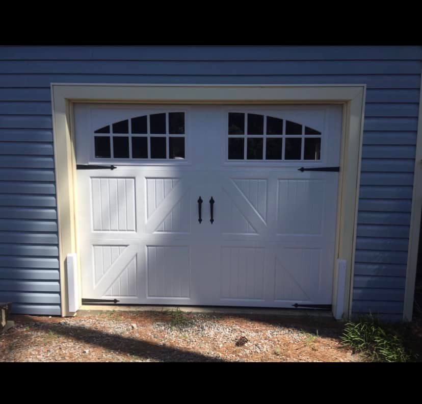 A white garage door on a blue house