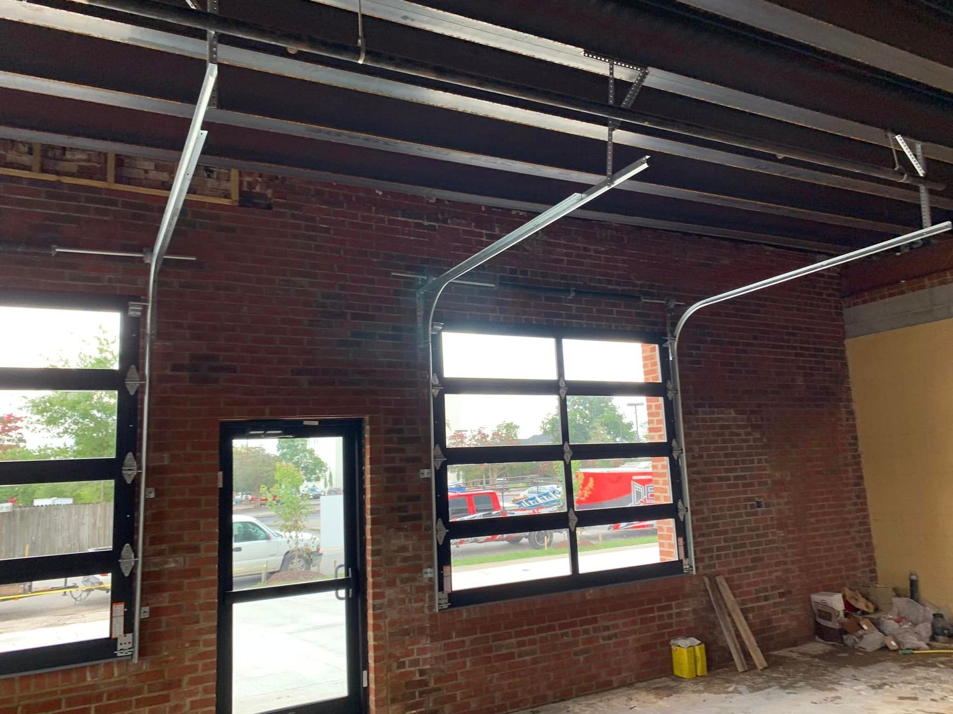 A room with a brick wall and a garage door.