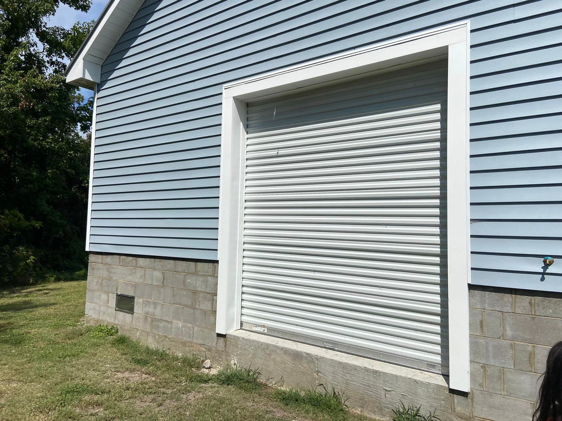 A blue house with a white garage door.