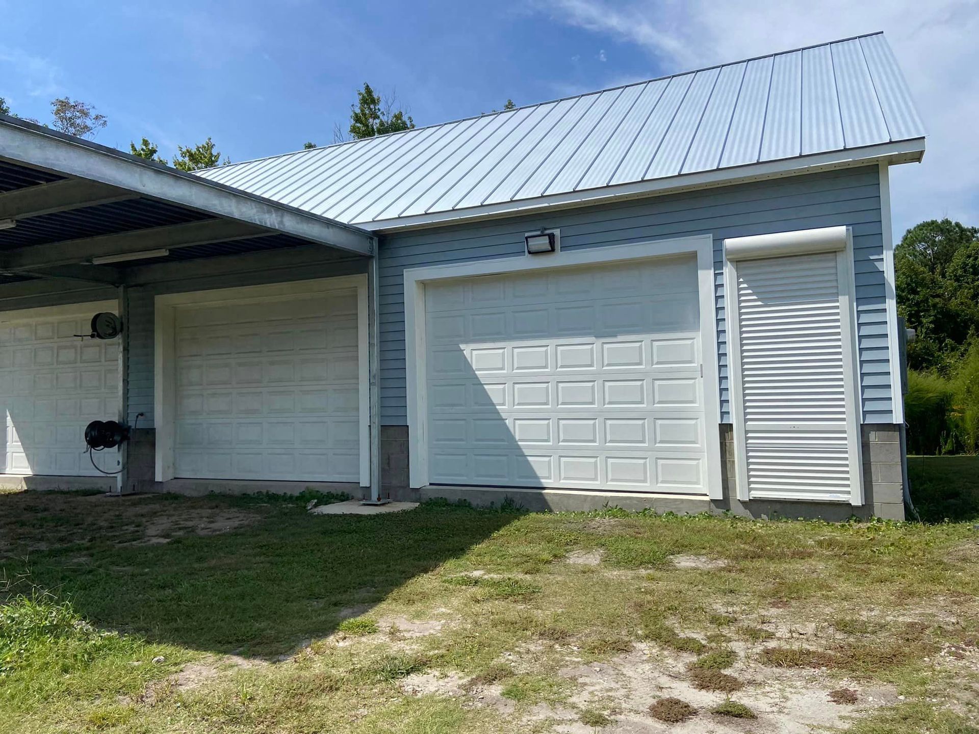 There are two garage doors on the side of a house.