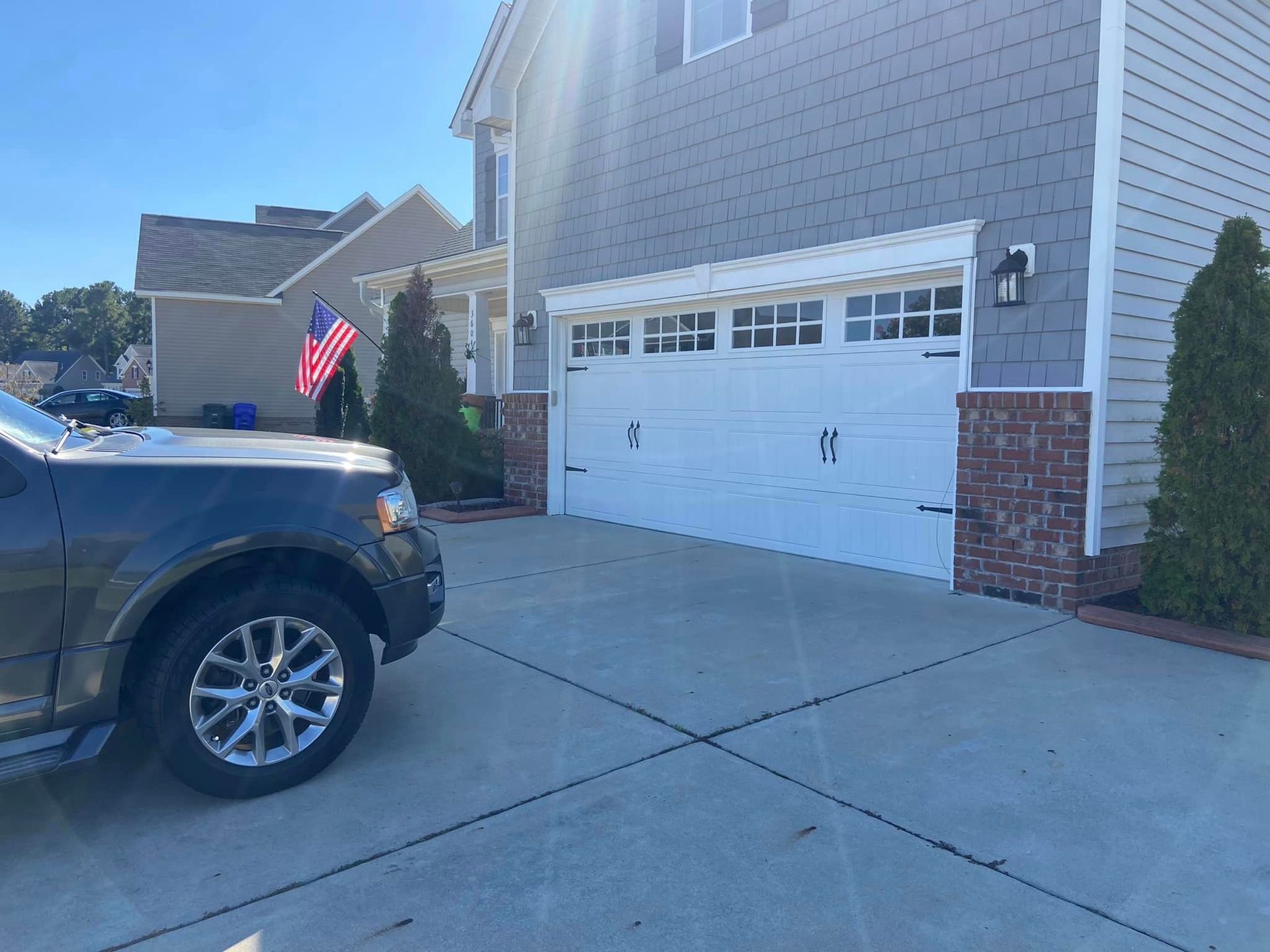 A truck is parked in front of a house with a garage door.