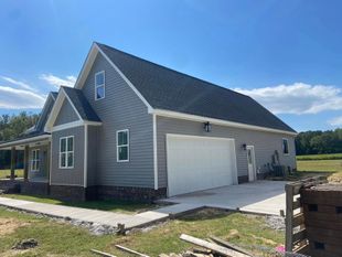 A house with a garage and a porch on a sunny day.