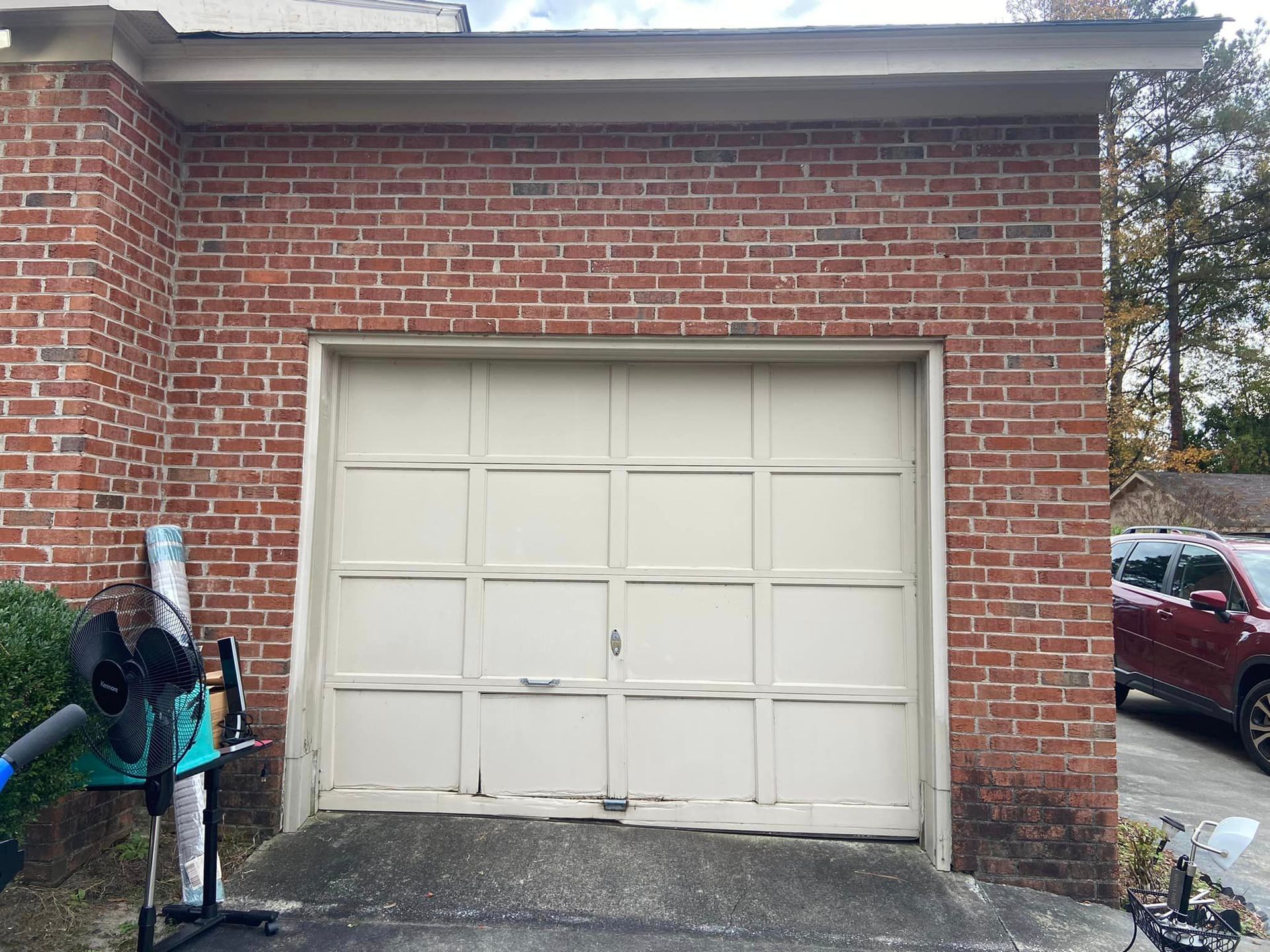 A brick garage with a white garage door