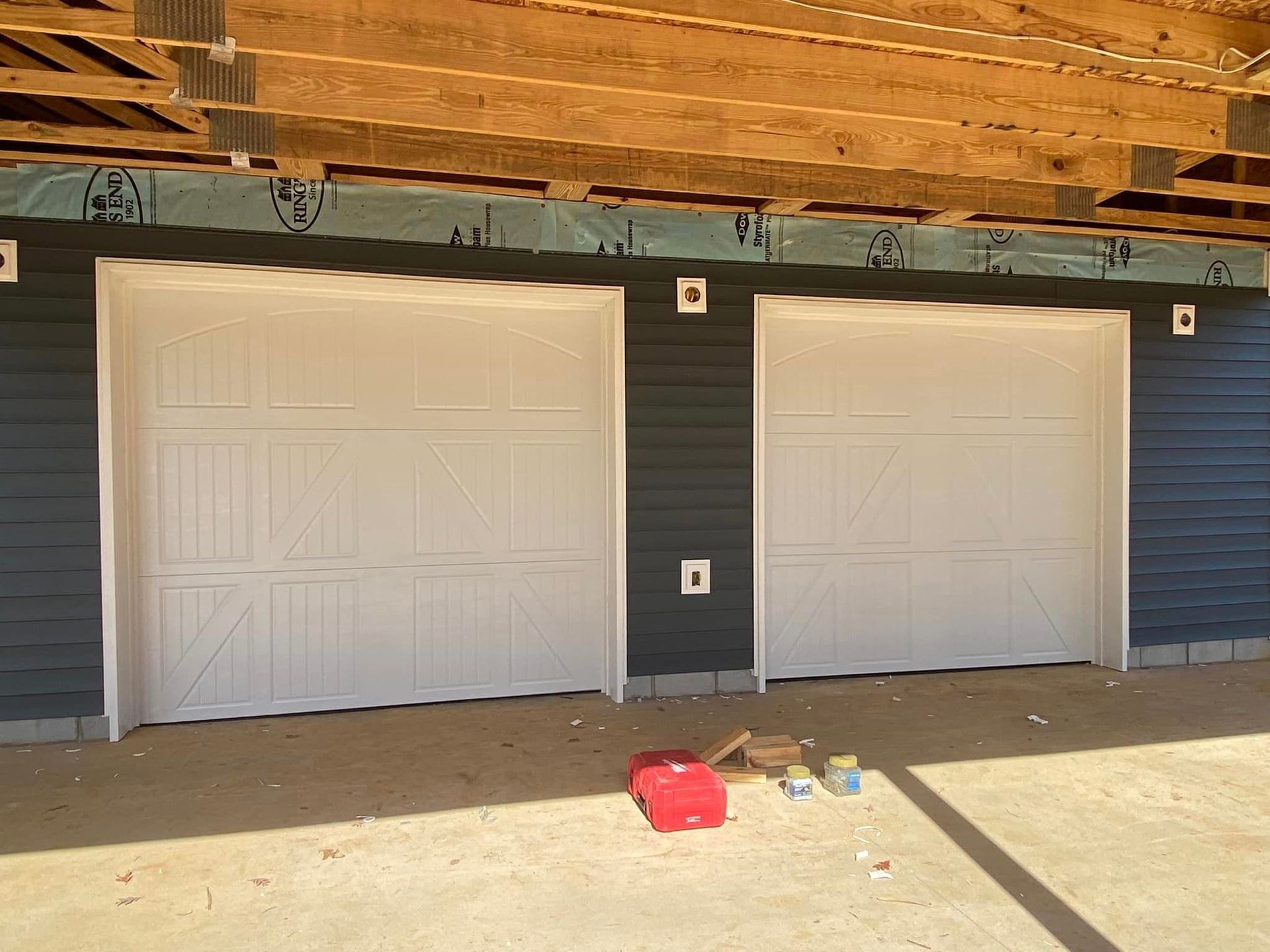 A row of garage doors with a red toolbox in front of them