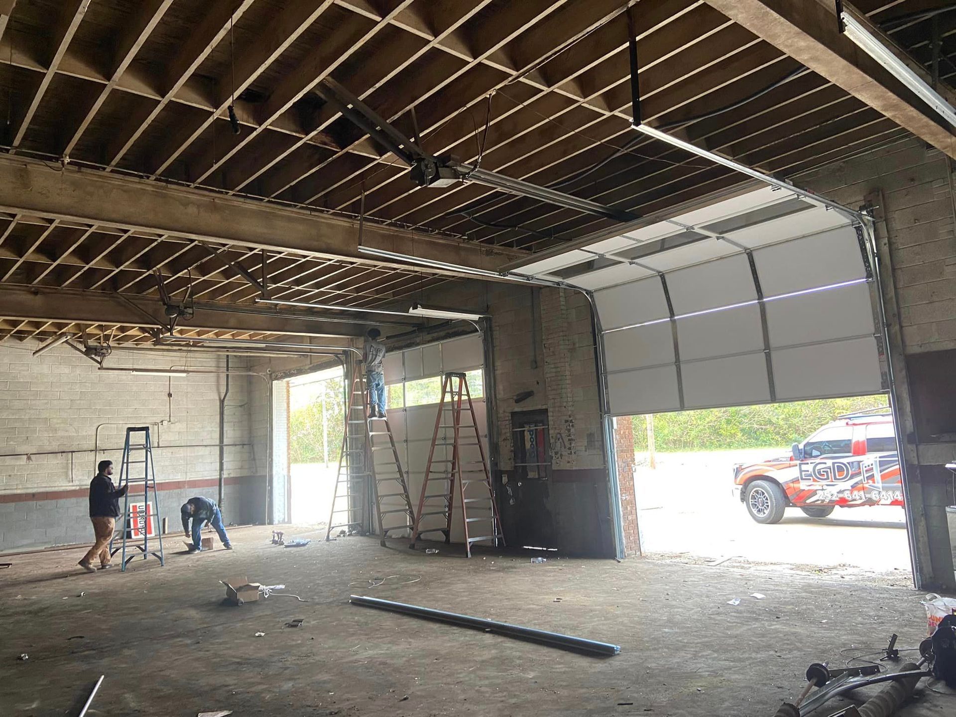 A large empty garage with a car parked in the background.