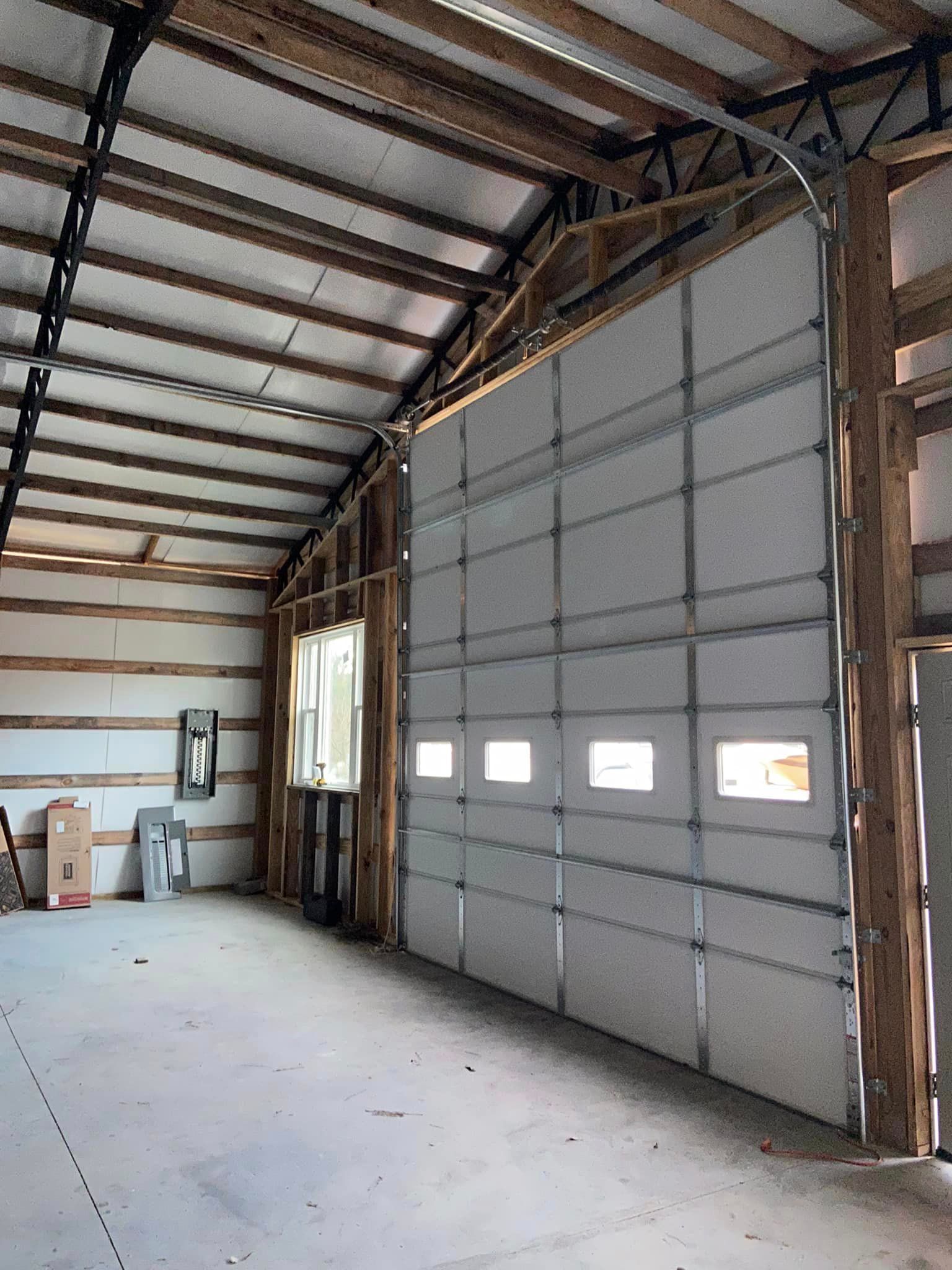 A large garage door is open in a building under construction.