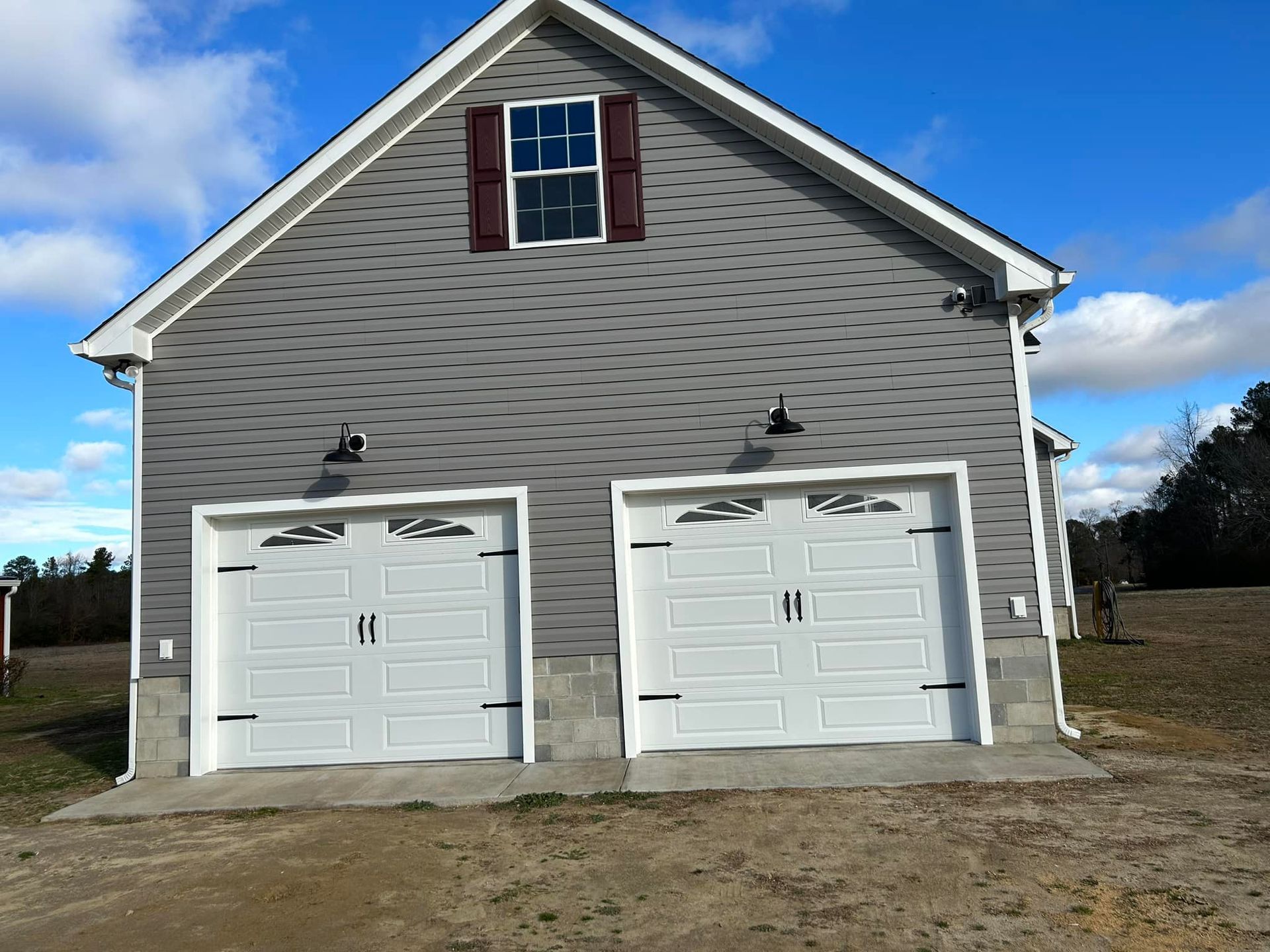 A garage with two white garage doors and a window