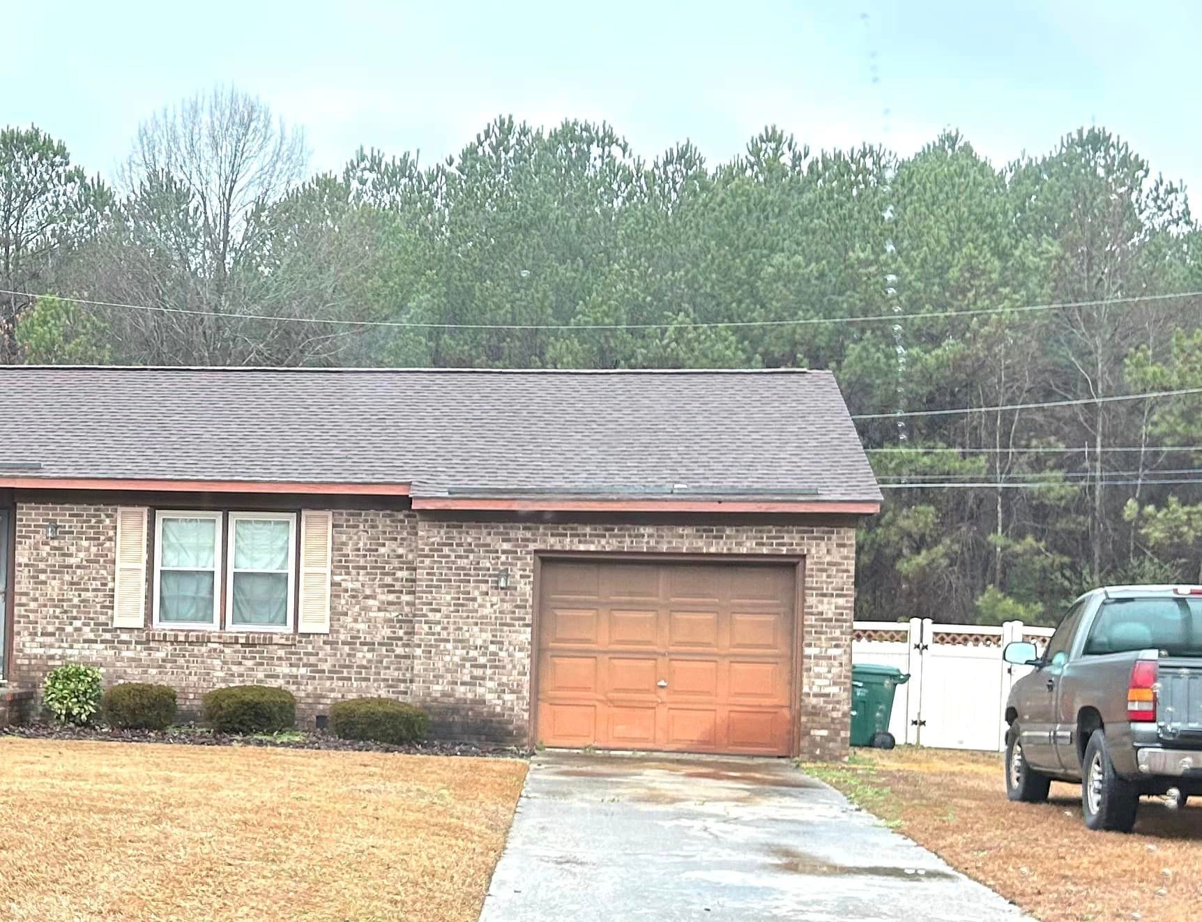 A truck is parked in front of a house with a garage door