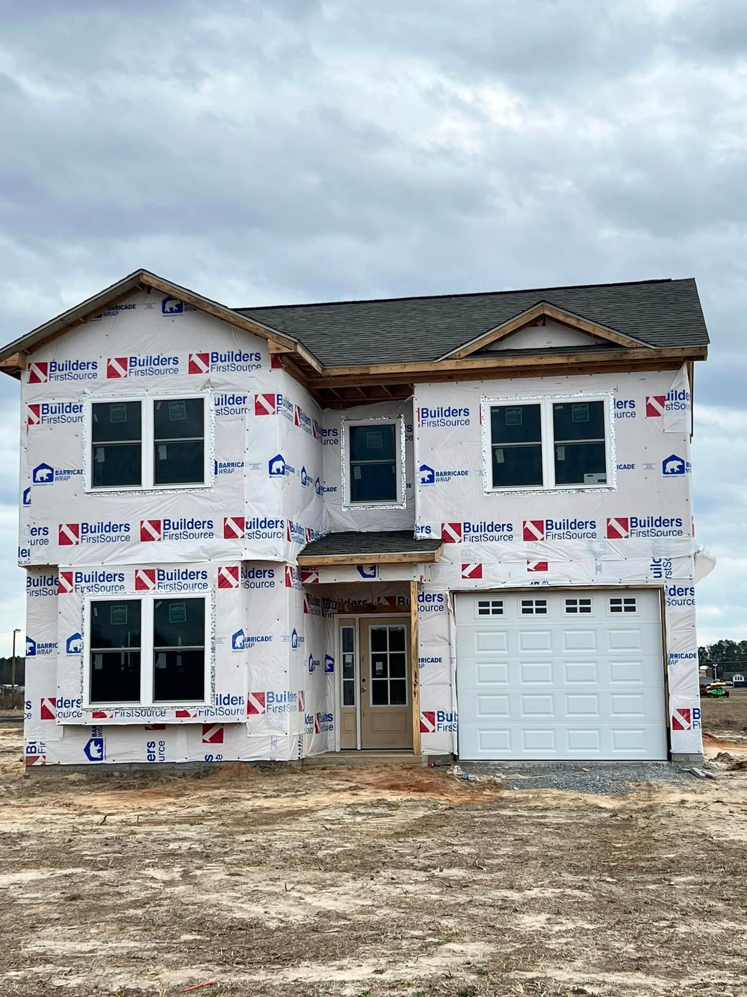 A house is being built in a field with a garage door.