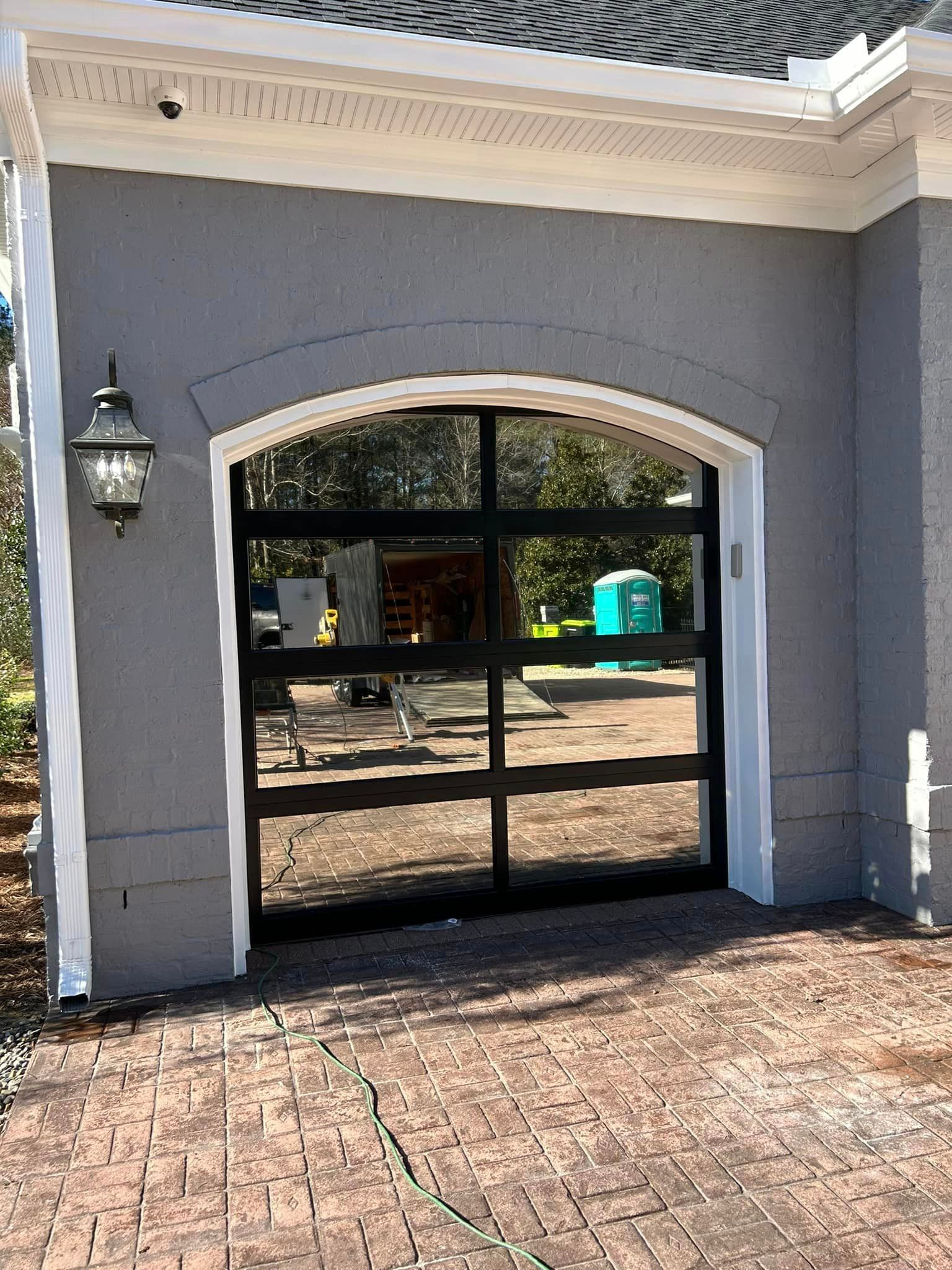 A garage door with a large window on the side of a house.