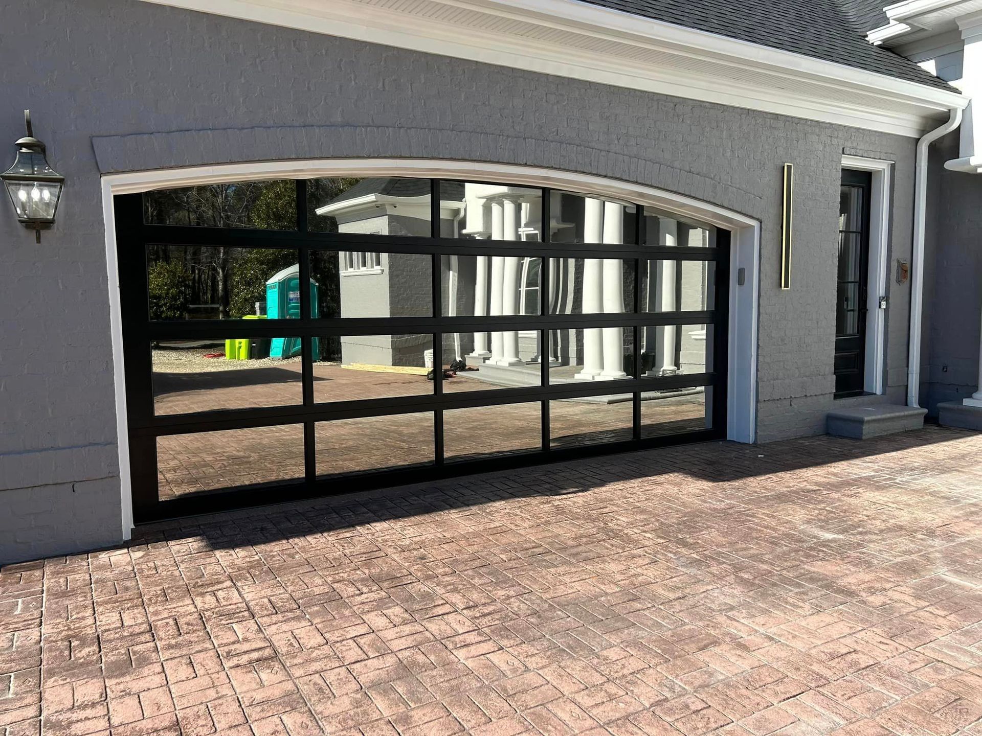 A black garage door is sitting in front of a house.