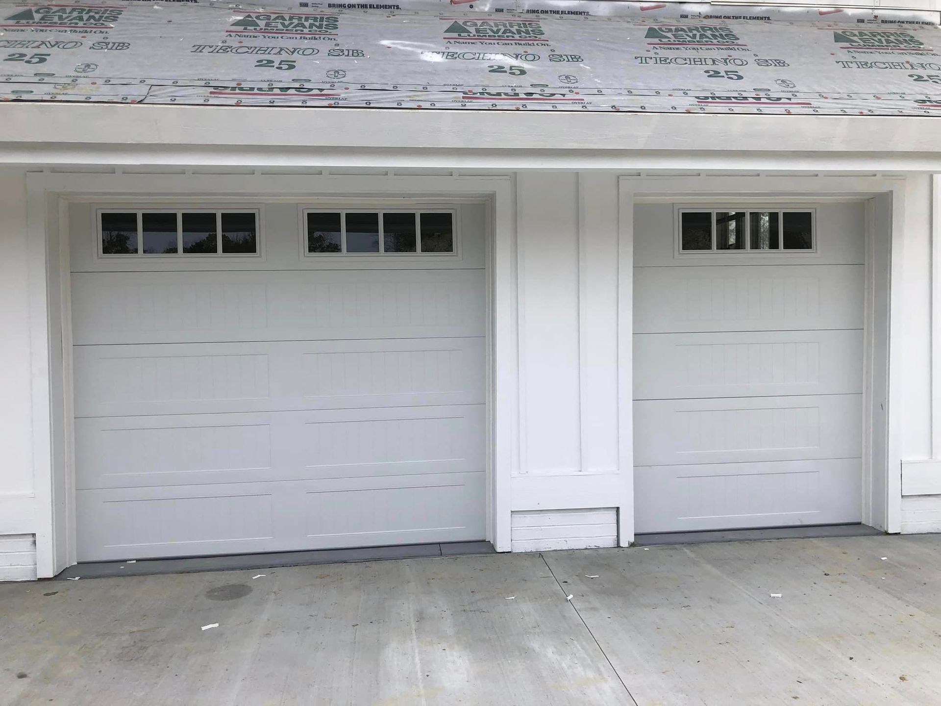 A white garage door with a window on the side of it.