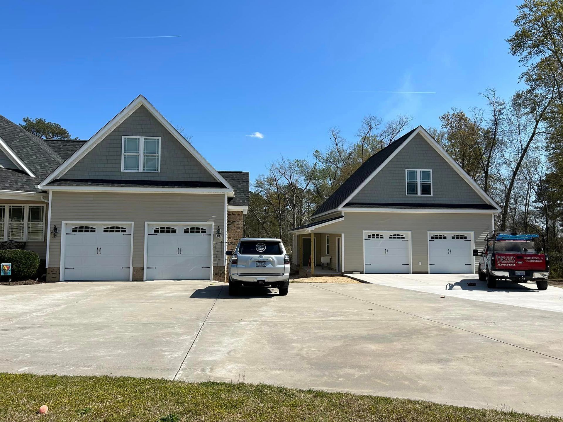 Two cars are parked in front of a large house