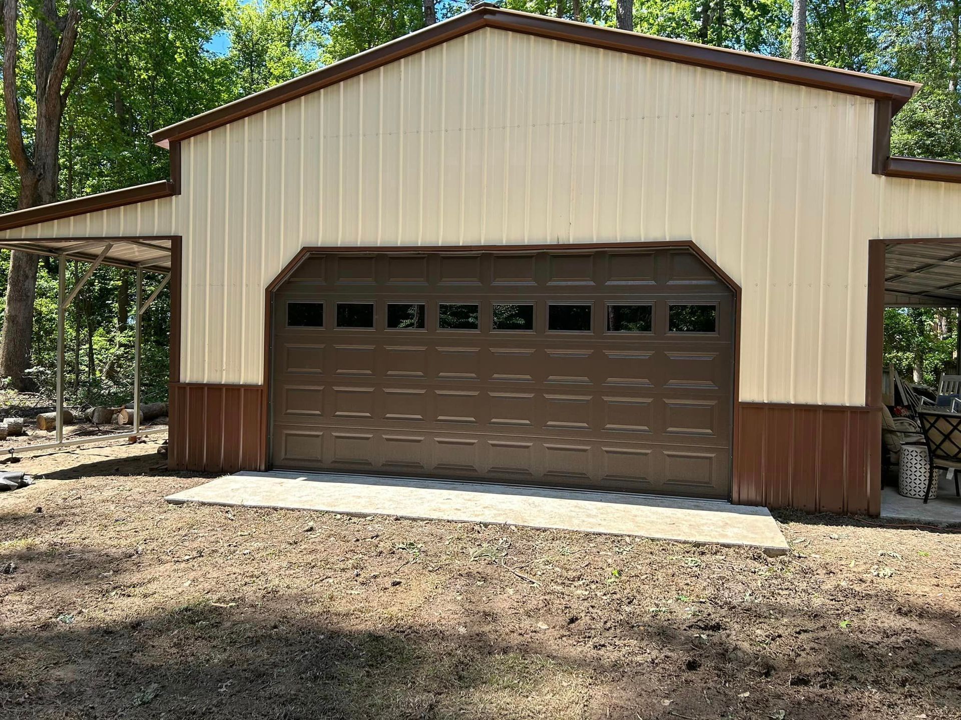 A large metal garage with a brown garage door and a canopy.