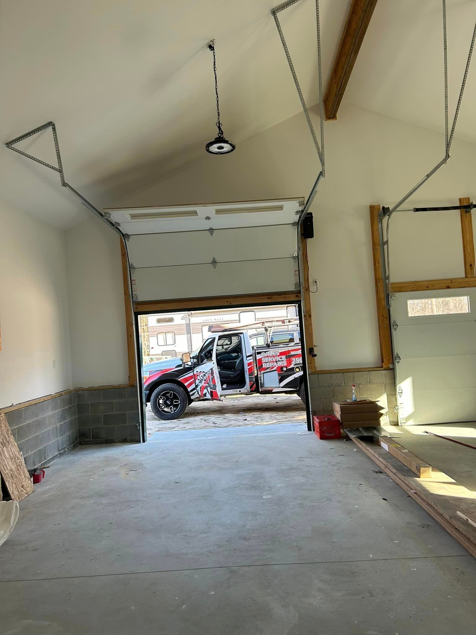 A car is parked in a garage with the door open.