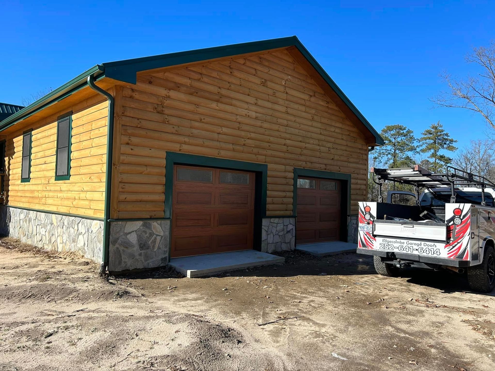 A truck is parked in front of a wooden garage.