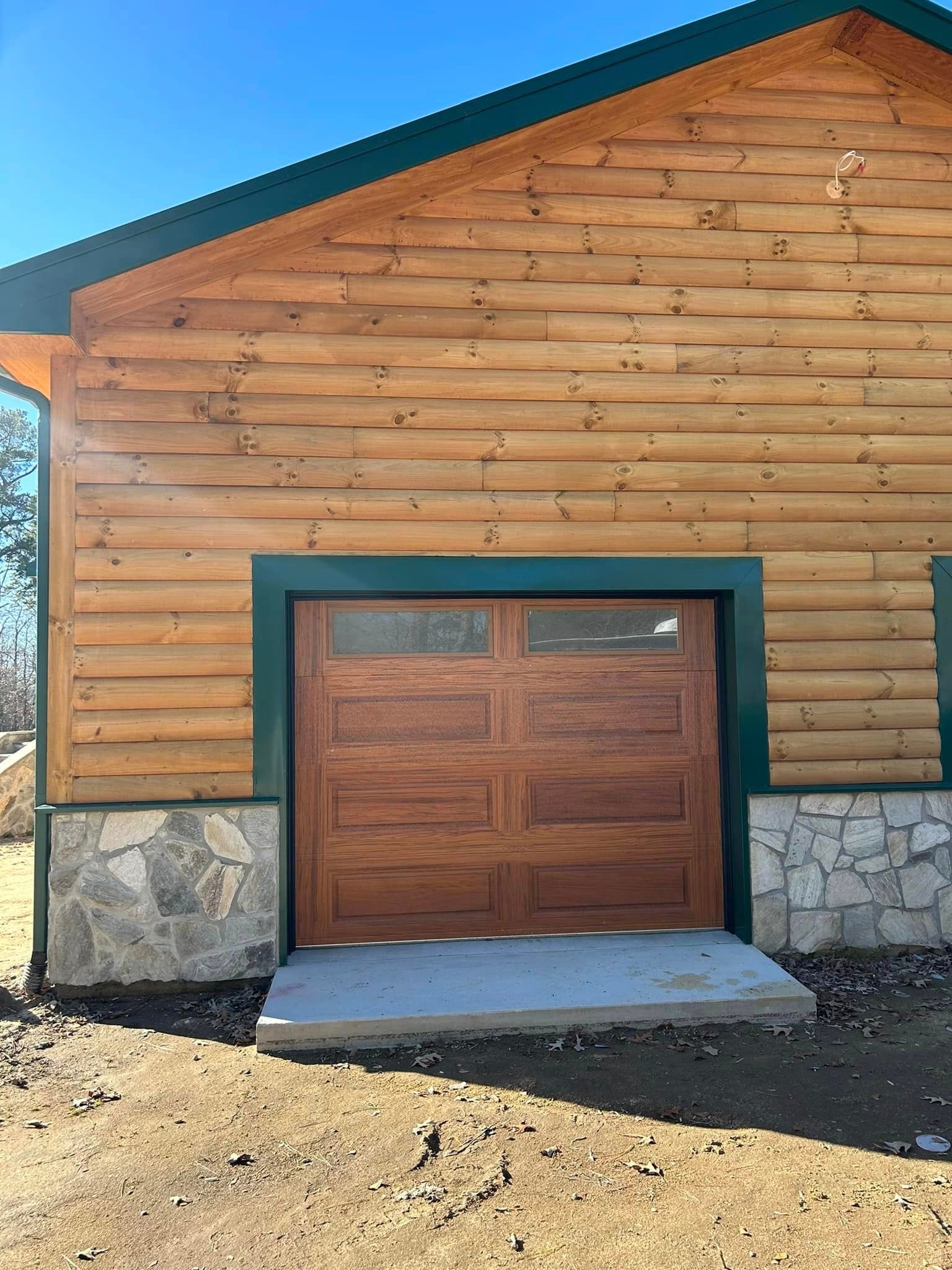 A log cabin with a large wooden garage door