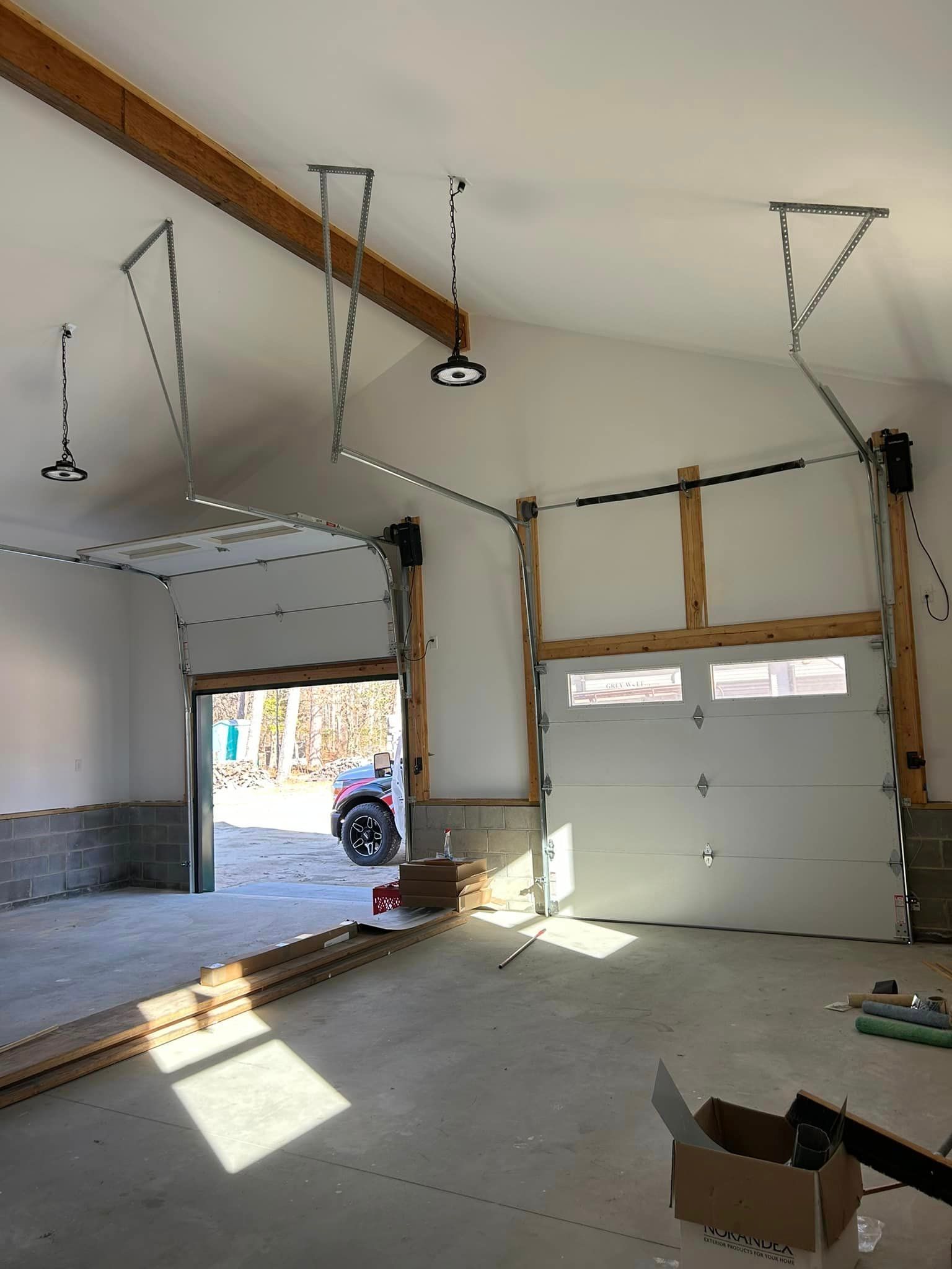 A garage with a car parked in it and a garage door open.