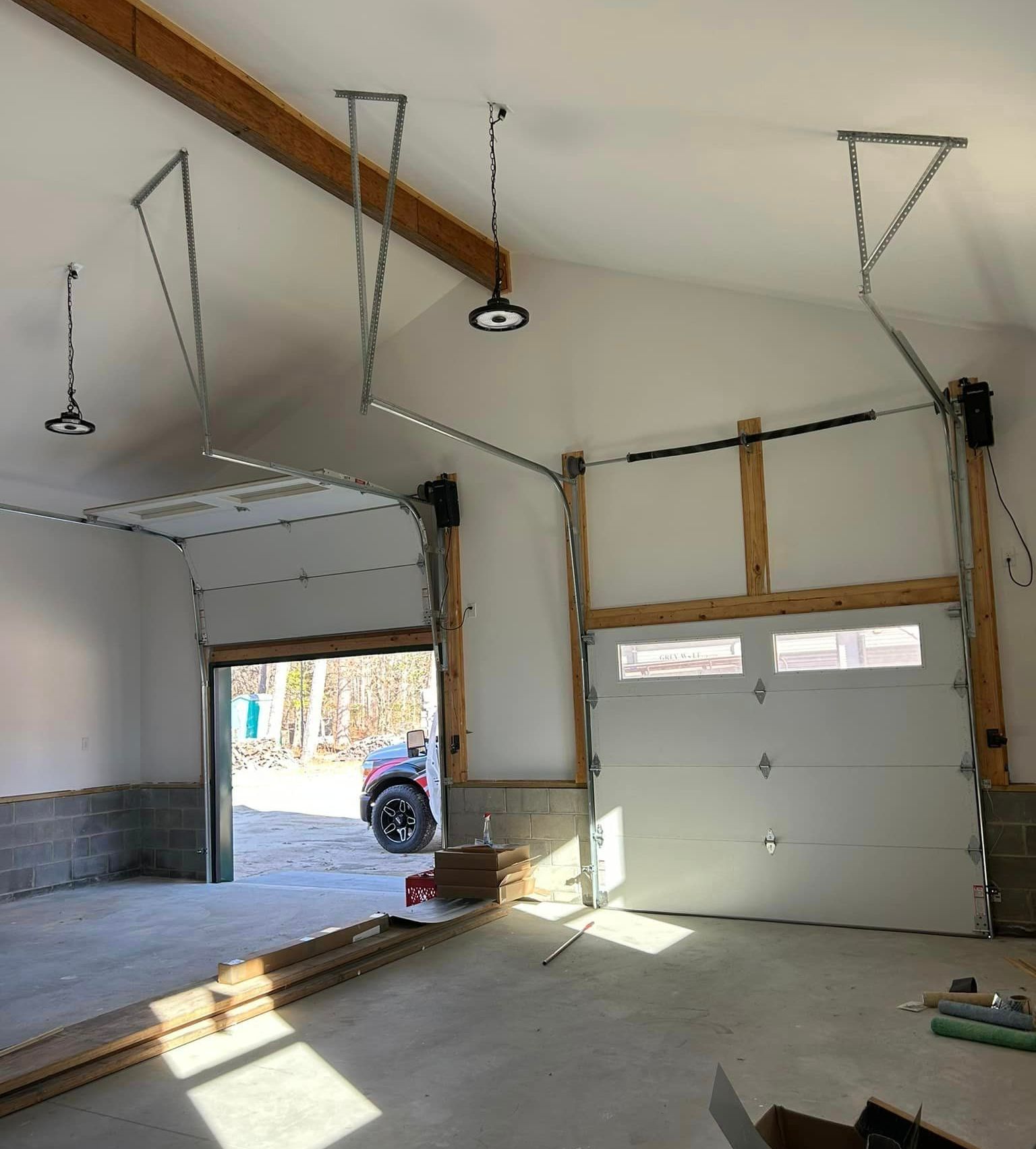 A garage with a car parked in it and a garage door open.